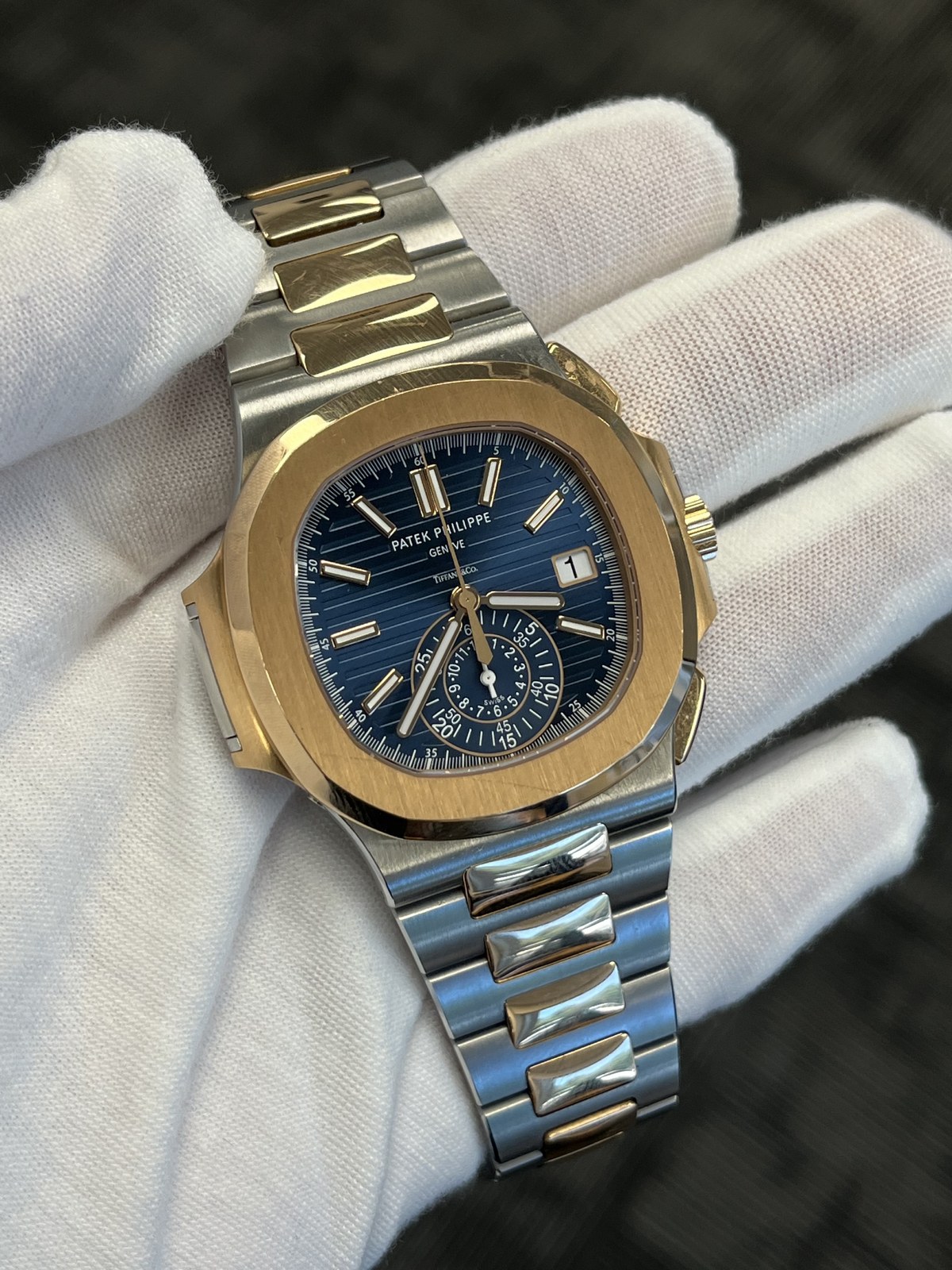 Patek Philippe Nautilus luxury watch held in a white glove