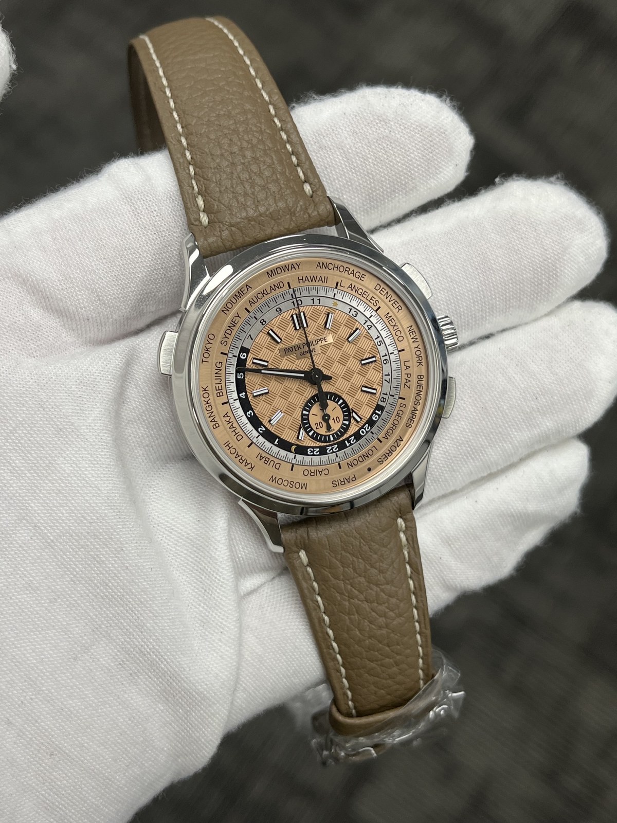 Patek Philippe world time watch held in a white glove